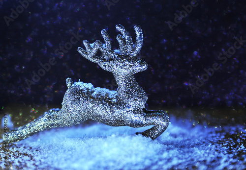 Christmas glitter deer on violet sparkling background. Neon light. Christmas concept. © Alona
