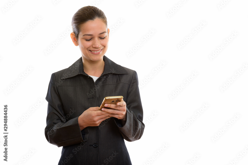 Studio shot of young happy businesswoman smiling while using mob Studio shot of young happy businesswoman smiling while using mob