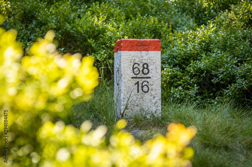 Obraz na płótnie Czech border pillar red and white color, at the boundary of Poland and Czech Republic. Forest scene. w salonie