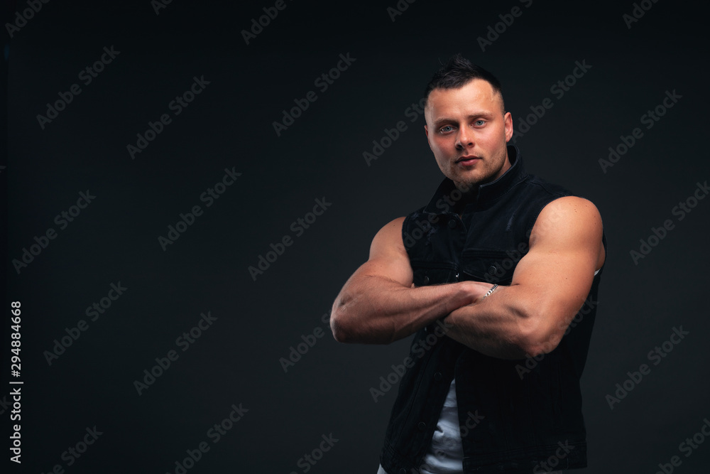 Strong and handsome young man with muscles and biceps. Studio shooting on black background. Strong and handsome young man with muscles and biceps. Studio shooting on black background.