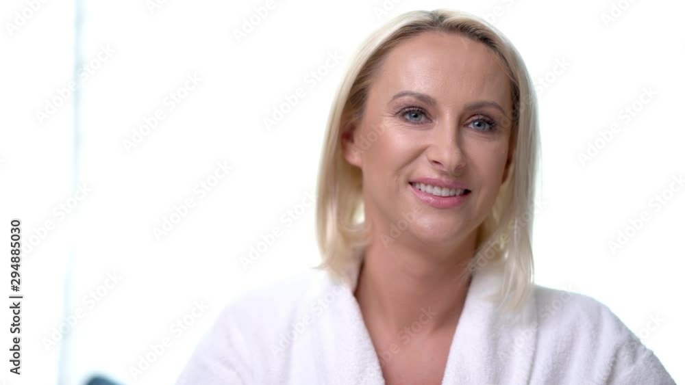 Adult blond woman drinking coffee in bathrobe in the morning Adult blond woman drinking coffee in bathrobe in the morning