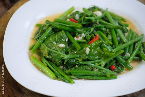 Stir Fried Chayote leaf with chili and garlic on white plate , Thai food.