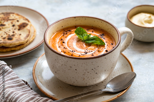 red lentil soup with bread and sour cream on white marble background. Homemade red lentil soup puree and flatbread. Healthy eating.