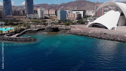 Drone aerial approach rocky coastline next to Auditorio de Tenerife auditorium concert hall and Torres de Santa Cruz Canary Islands photo