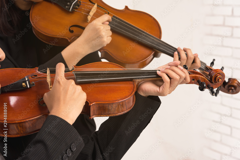 In violin practice class,two beautiful woman hold wooden violin.teach and practice playing violin together to prepare for the concert. In violin practice class,two beautiful woman hold wooden violin.teach and practice playing violin together to prepare for the concert.