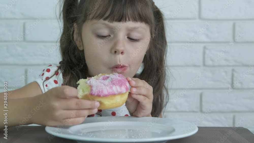 Beautiful child eats a donut with icing. Beautiful child eats a donut with icing.