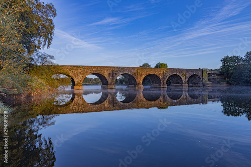 Stone Bridge at Portneal near Kilrea with reflection on the water and low lying mist just after dawn