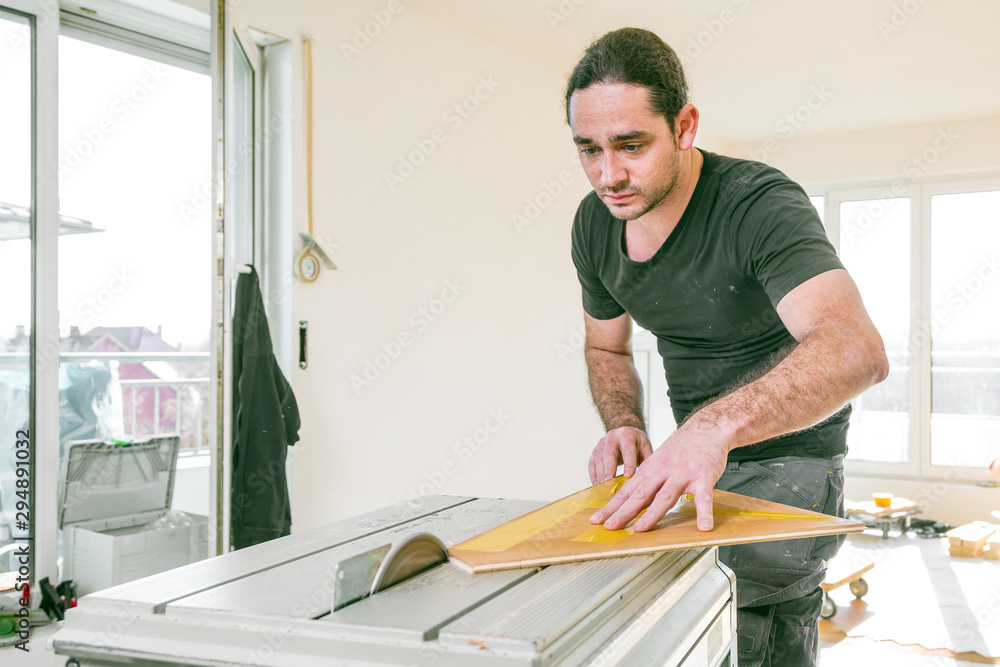 Handwerker schneidet parkett mit Kreissäge in einem neubau haus Handwerker schneidet parkett mit Kreissäge in einem neubau haus