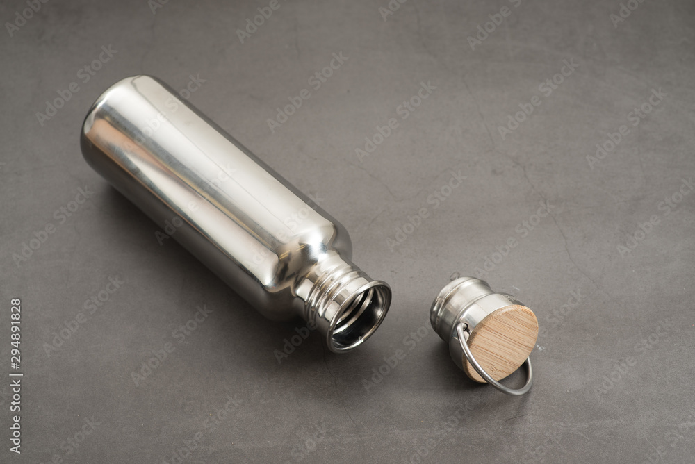 Durable, high quality reusable stainless steel bottle on gray background as alternative to plastic bottles. Toxin, BPA, plastic free zero waste option for drinking tap water at home or at the office. Durable, high quality reusable stainless steel bottle on gray background as alternative to plastic bottles. Toxin, BPA, plastic free zero waste option for drinking tap water at home or at the office.