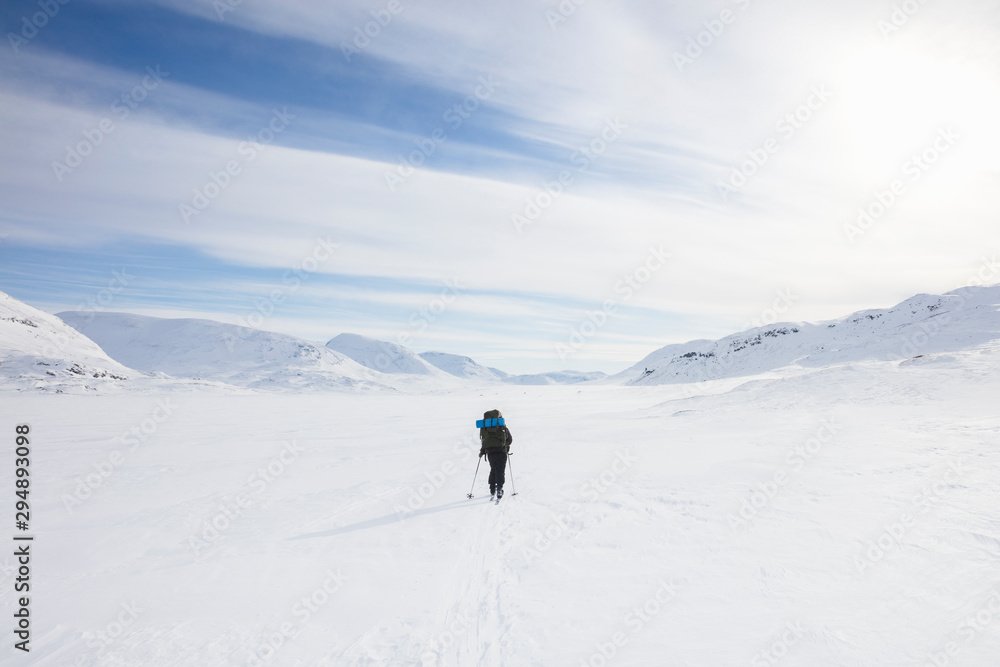 Woman skiing by mountains on Kungsleden train in Lapland, Sweden Woman skiing by mountains on Kungsleden train in Lapland, Sweden