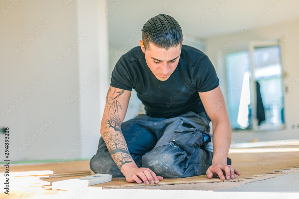 Handwerker bei der arbeit, fischgrät parkett verlegen ,sockelleisten montage . Handwerker bei der arbeit, fischgrät parkett verlegen ,sockelleisten montage .