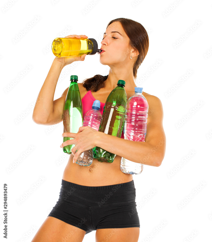Young athletic girl drinks water from a bottle - isolated on white background Young athletic girl drinks water from a bottle - isolated on white background