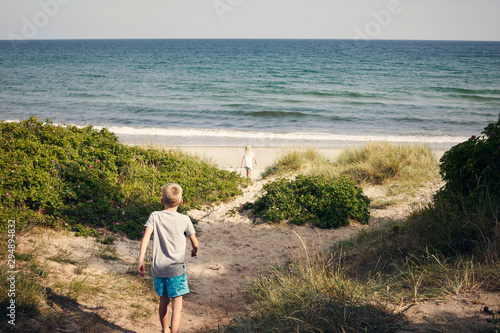 Boy and girl walking to beach photo
