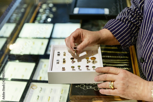 Hands of goldsmith examining box of rings photo