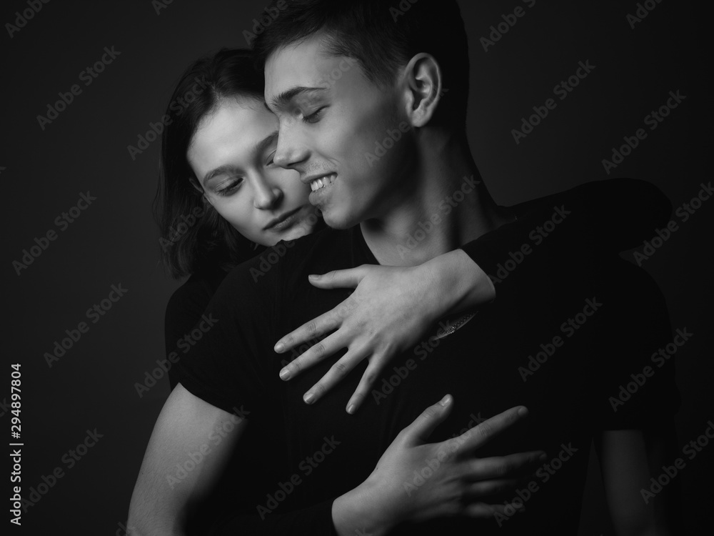 Young couple posing in studio. Low key. Black and white Young couple posing in studio. Low key. Black and white