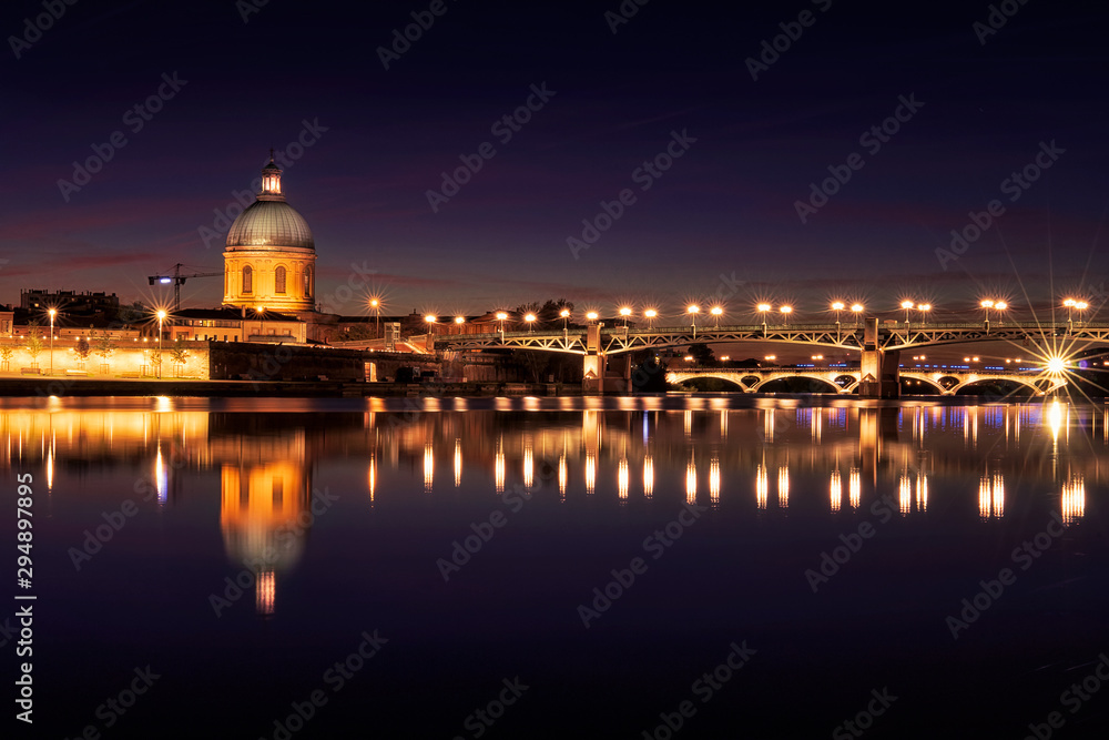 Long exposure photo of the Garonne  river, Saint-Pierre Bridge and Hospital de la Grave at night.  Toulouse. South France. Europe