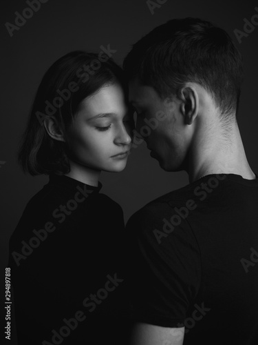 Young couple posing in studio. Low key. Black and white