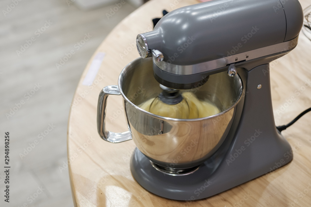 Mixing eggs, flour and sugar in bowl with motor mixer. Preparing ingredients for baking a cake. Mixing eggs, flour and sugar in bowl with motor mixer. Preparing ingredients for baking a cake.