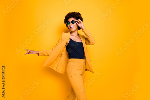 Portrait of positive cheerful lady feel candid expression enjoy rest relax on free time wear stylish fashionable clothes isolated over yellow color background