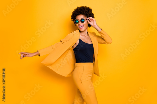 Profile side photo of positive cheerful afro american girl have rest relax look enjoy fall holidays wear fashionable vogue suit isolated over yellow color background