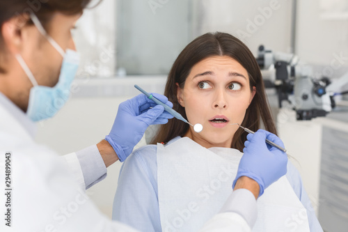 Scared woman looking at dentist before treatment