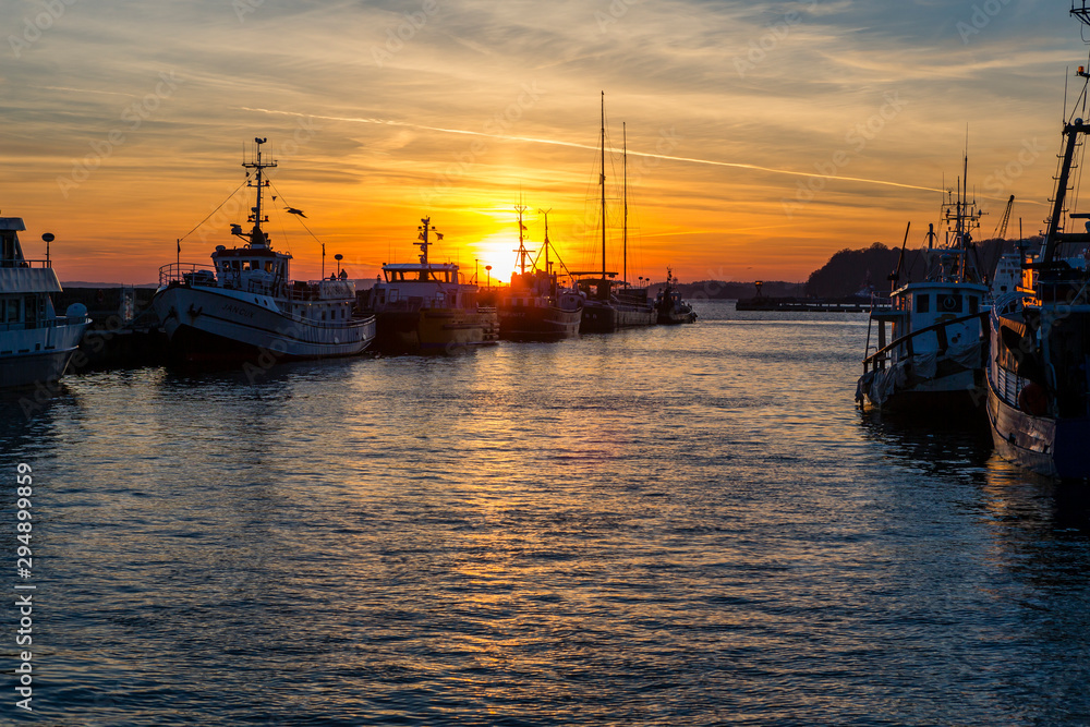 Fishing boats in harbor of Sassnitz at ruegen island. The sun sets in the background, Sassnitz, Ruegen Island