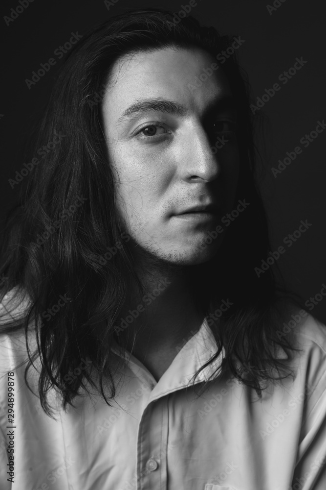 Portrait of young man with long hair. Black and white. Close up. Portrait of young man with long hair. Black and white. Close up.