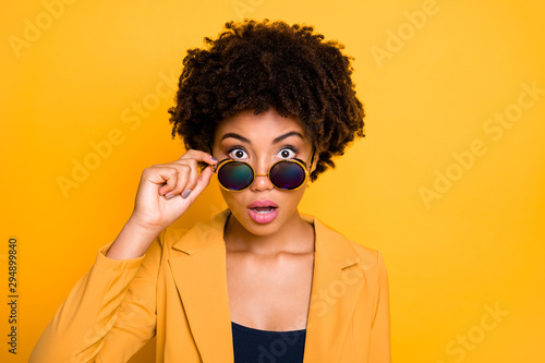 Close-up portrait of her she nice attractive pretty lovely shocked speechless wavy-haired girl touching specs staring eyes isolated over bright vivid shine vibrant yellow color background photo