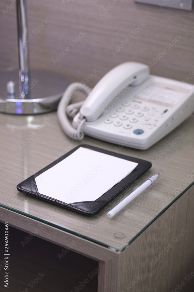 Blank note paper and pencil on the beside table in a hotel room. Blank note paper and pencil on the beside table in a hotel room.
