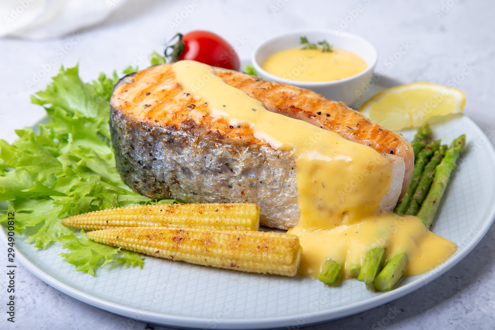Grilled salmon with asparagus, corn mini and hollandaise sauce. Close-up. Grilled salmon with asparagus, corn mini and hollandaise sauce. Close-up.