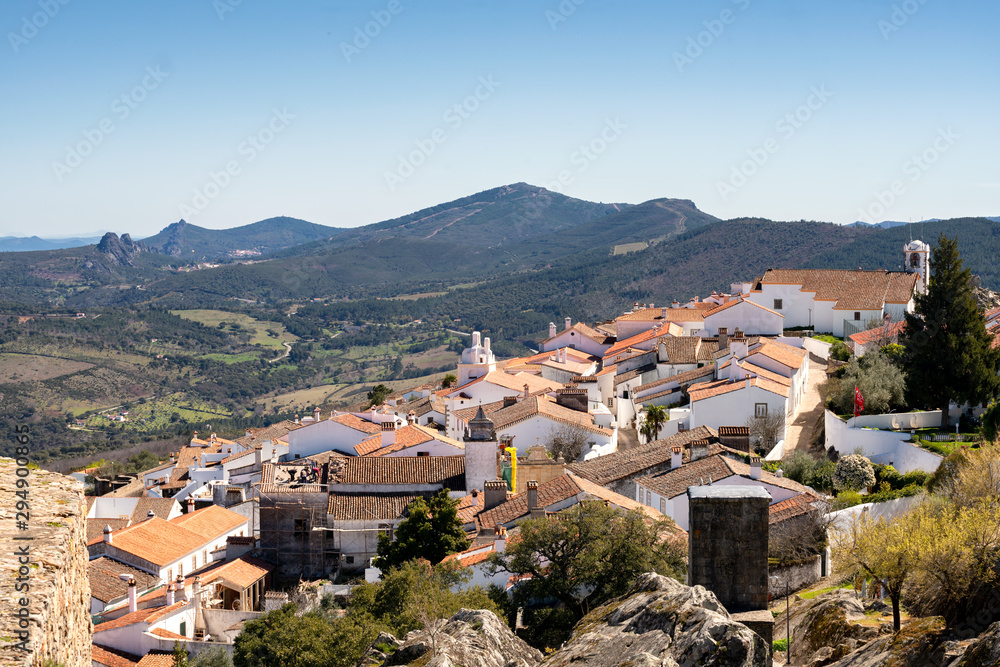 View of Marvao village with beautiful houses and church with rocky landscape mountains behind