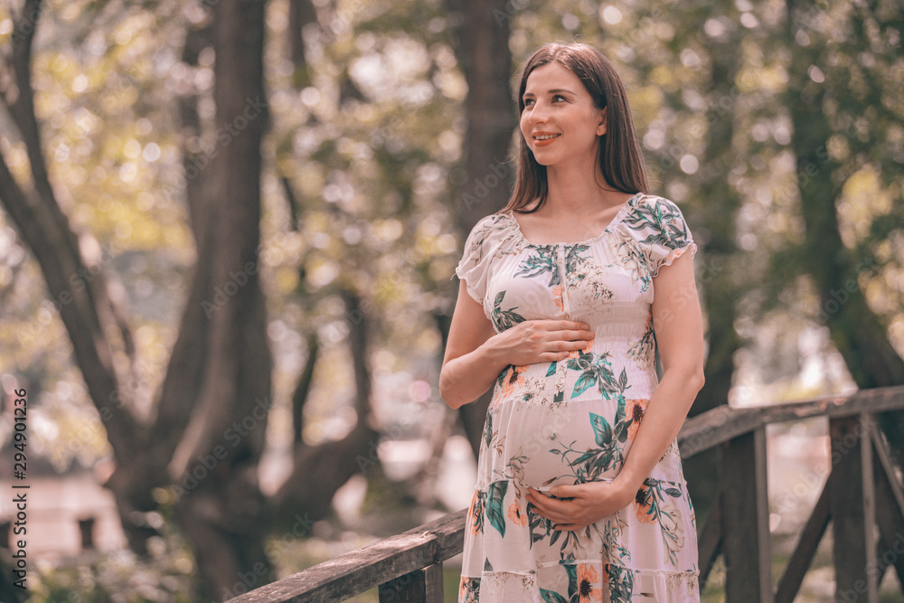 Pregnant woman posing in the park Pregnant woman posing in the park