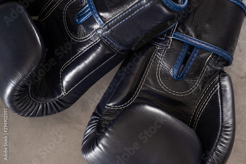 Navy Blue Boxing gloves on a industrial, rustic concrete floor background. © Colin