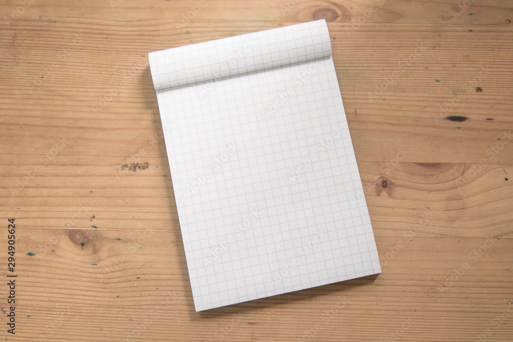 Mock up open blank grid notepad on a wooden table. Mock up open blank grid notepad on a wooden table.