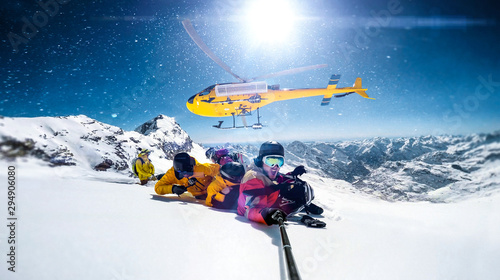 Photos Actionsportlers were dropped by a helicopter at the top of the mountains while one person is taking a smile selfie with a wide angle camera