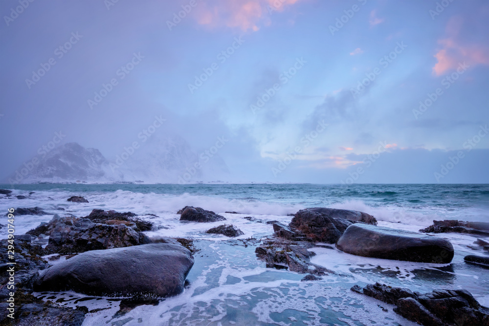 Coast of Norwegian sea on rocky coast in fjord on sunset