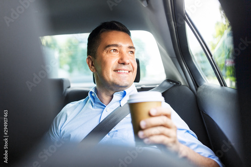 transport, business and people concept - businessman drinking takeaway coffee on back seat of taxi car © Syda Productions
