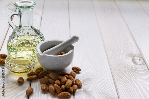 Concept almonds and almond oil in a bottle on a wooden table, copy space