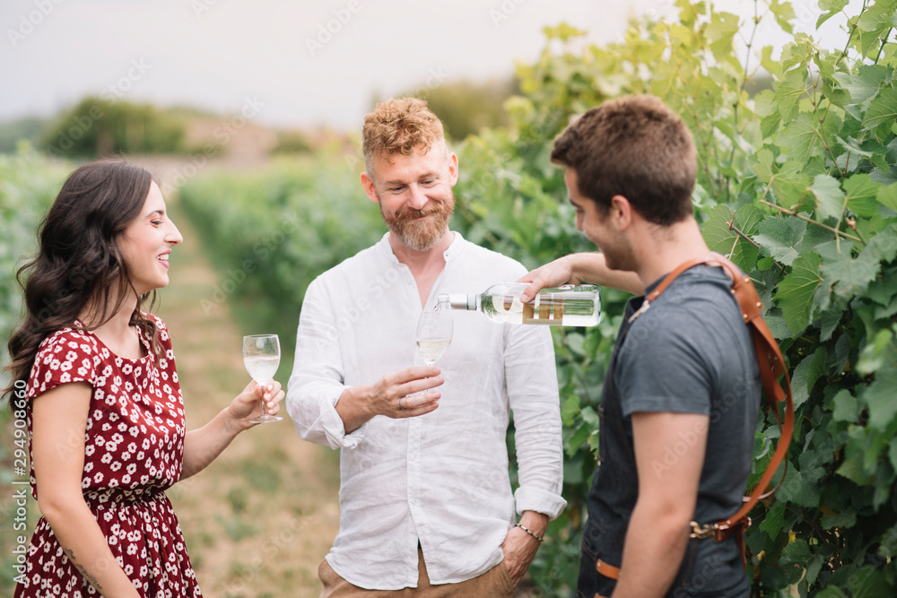Sommelier with customers in the vineyard Sommelier with customers in the vineyard