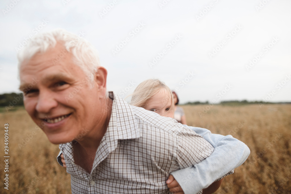 Grandfather giving his granddaughter a piggyback ride Grandfather giving his granddaughter a piggyback ride
