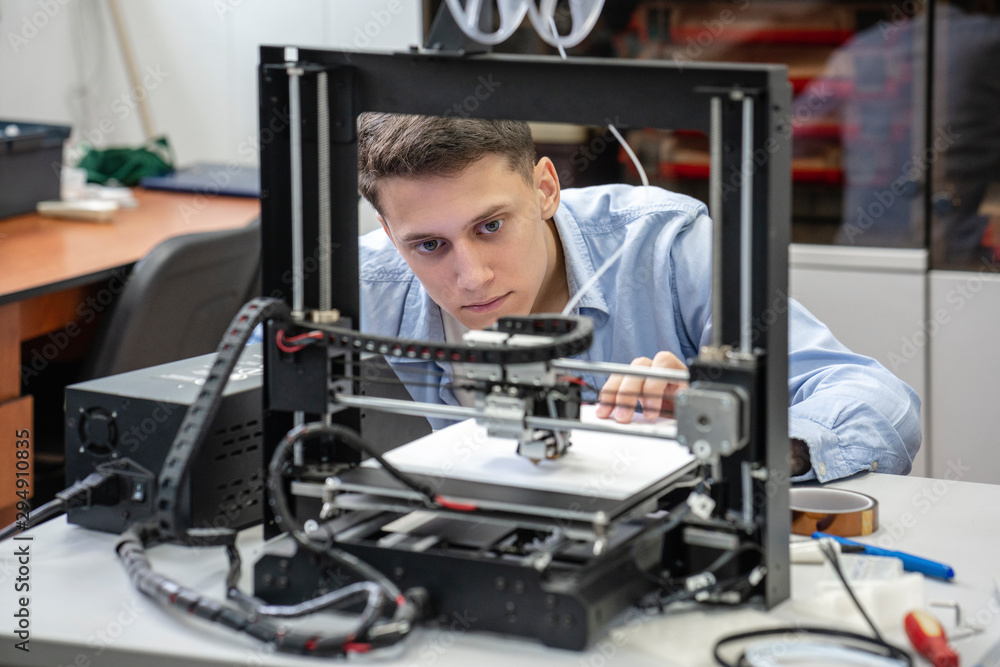 Student setting up 3D printer Student setting up 3D printer
