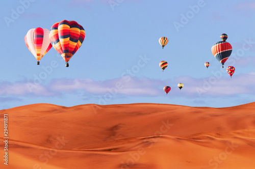 Colorful hot air balloons flying over sand dune seven, Walvis Bay, Namibia.