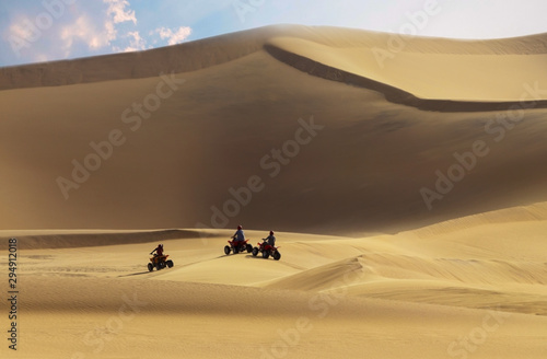 Driving off-road with quad bike or ATV vehicles. Namib sand desert on the background