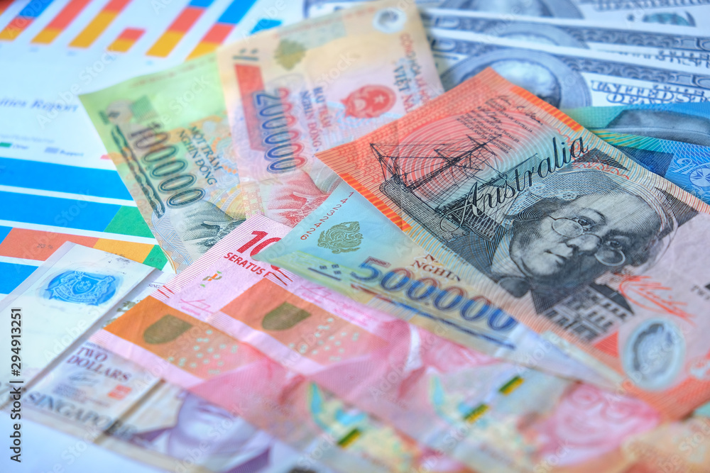 Obraz premium Business and Financial Concept. Multiple Currencies Banknote with laptop on graph and chart.