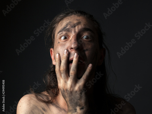Φωτογραφία Portrait of a scared young man in smeared soot.