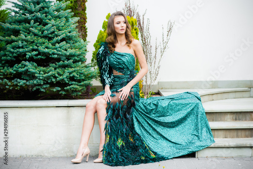 Obraz na plátně Fashionable emerald evening dress on a young woman with beautiful hair and makeu