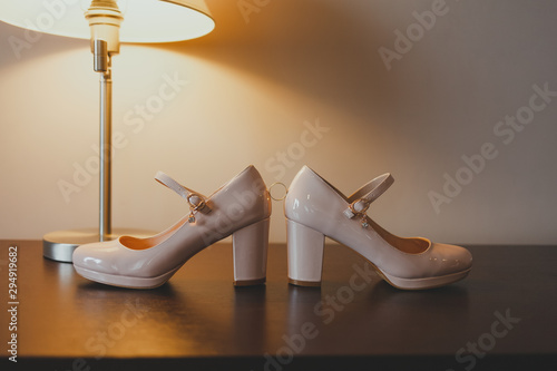 wedding ring lies between the shoes of the bride. wedding ring and bride shoes