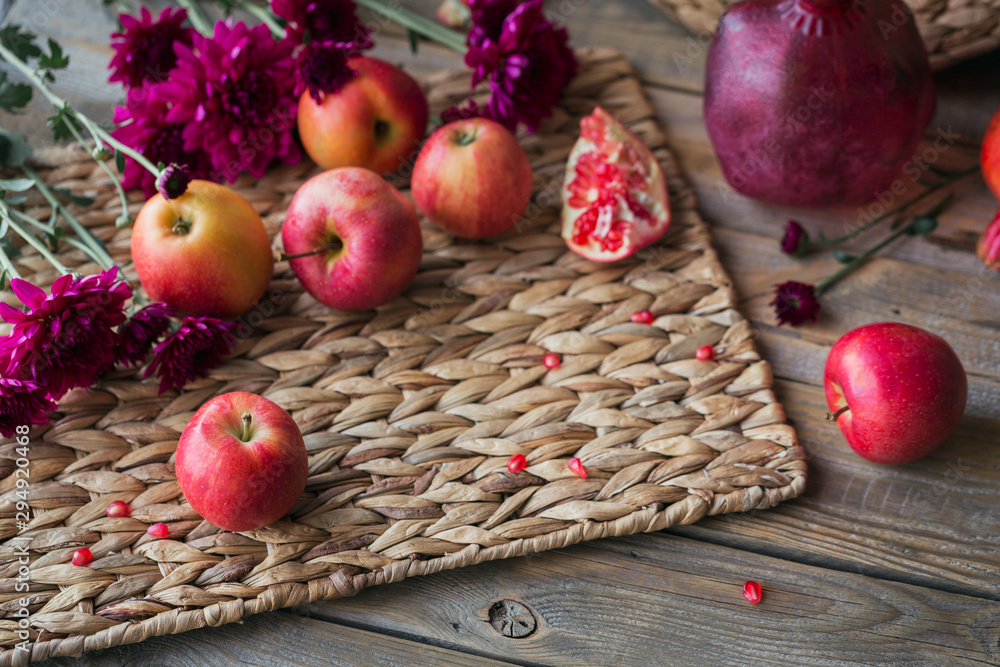 Harvest of red apples, grapefruit with autumn leaves and flowers on a wooden table Harvest of red apples, grapefruit with autumn leaves and flowers on a wooden table