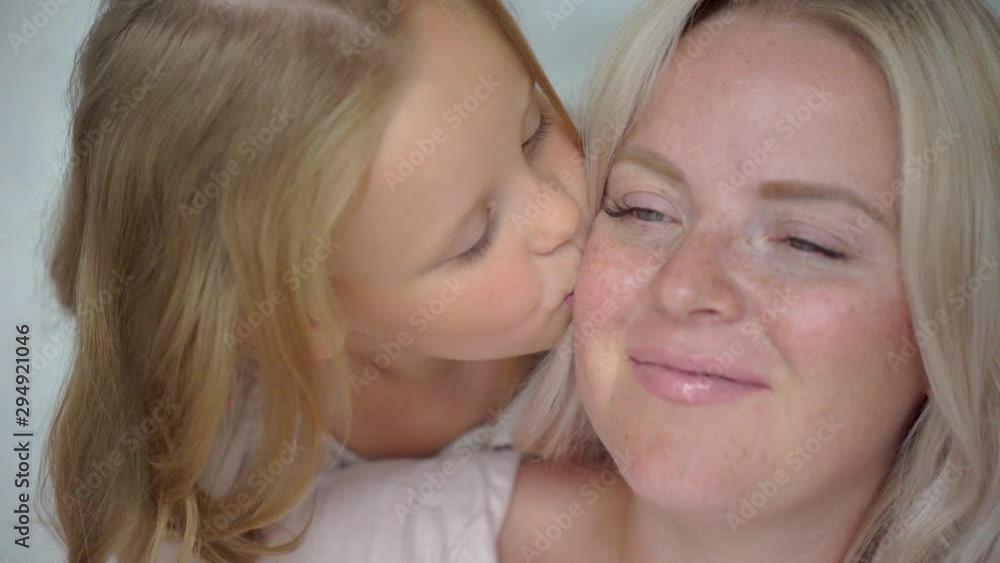 pregnancy, happy family. Little girl kissing and hugging her pregnant mom. Mother with daughter at home, having fun. Portrait of child daughter and mother looking at camera. Maternity Motherhood, 4 K pregnancy, happy family. Little girl kissing and hugging her pregnant mom. Mother with daughter at home, having fun. Portrait of child daughter and mother looking at camera. Maternity Motherhood, 4 K