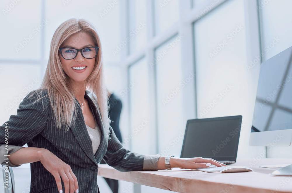 businesswoman sitting at her Desk and looking at the camera businesswoman sitting at her Desk and looking at the camera